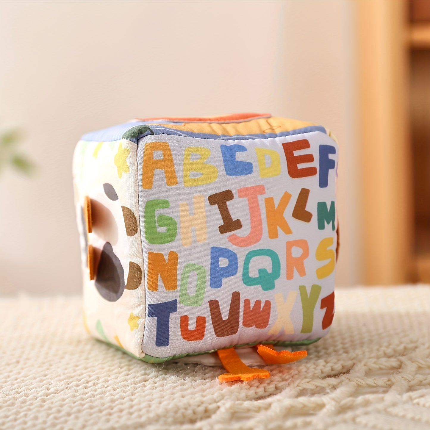 Baby sensory activity toy with colorful tissues in a play box to promote fine motor skills and tactile learning.