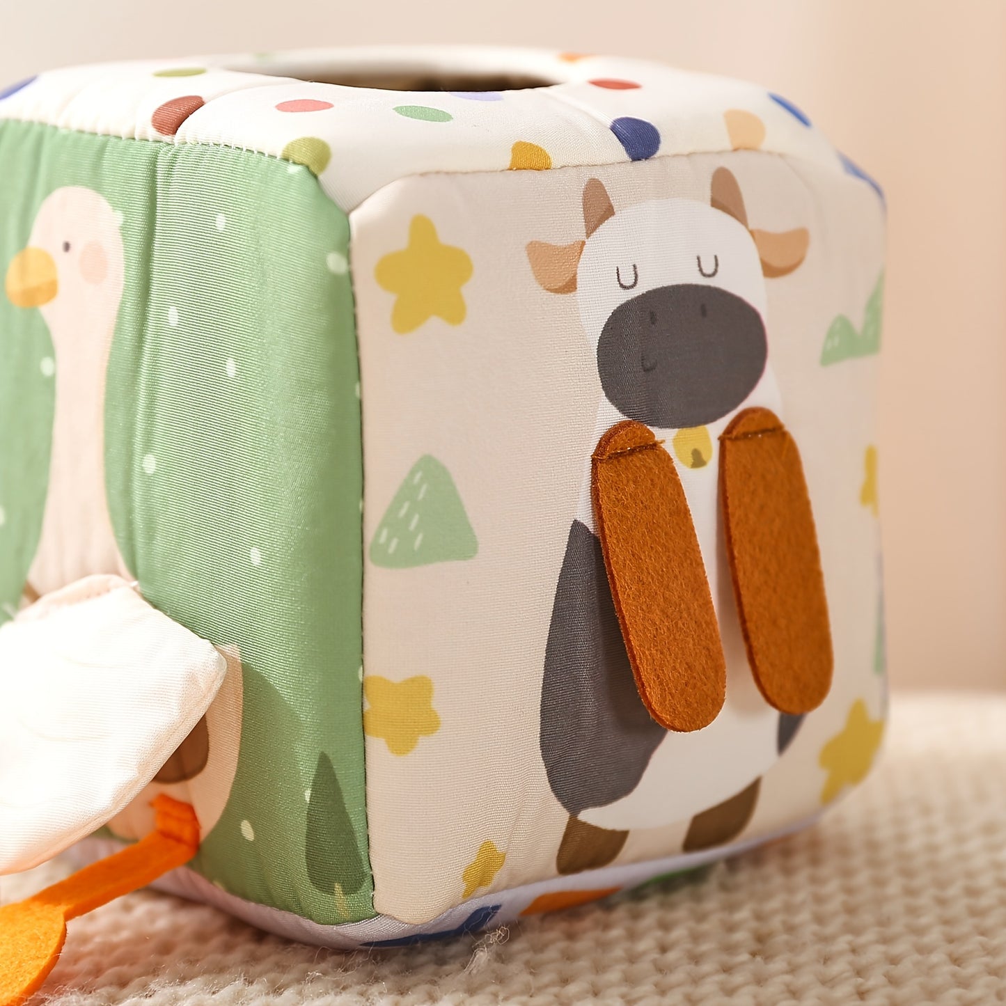 Soft colorful tissue box toy that fosters sensory engagement and hand-eye coordination in babies and toddlers.