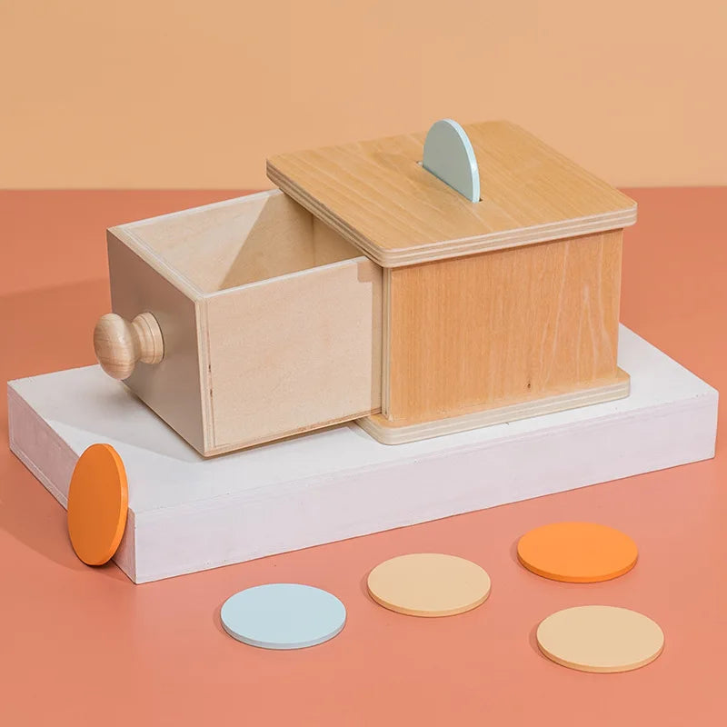 Close-up of coin-sized ball dropping into Montessori object permanence toy