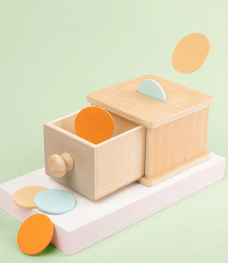 Montessori toy teaching object permanence with wooden ball and box