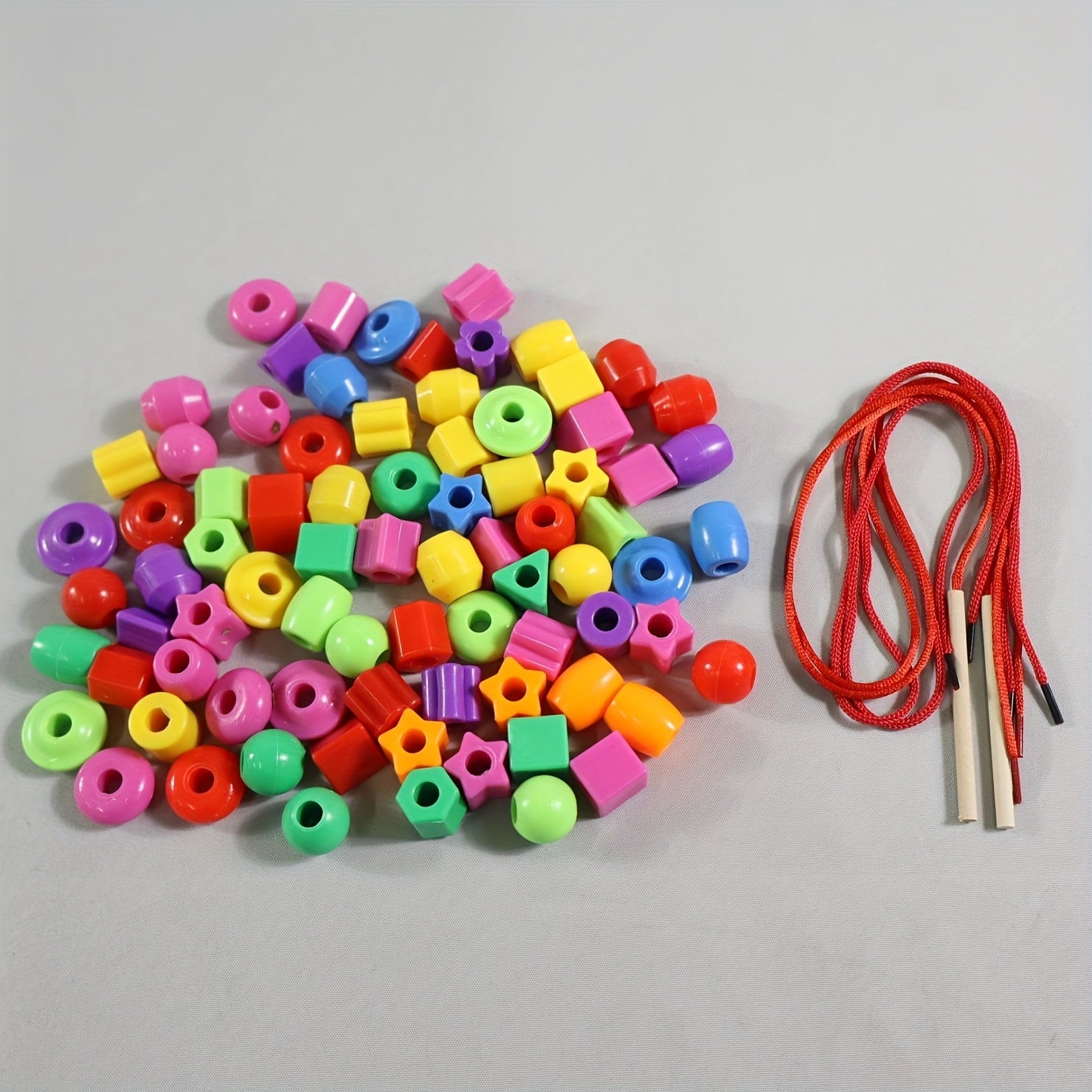 Assorted vibrant beads in various shapes laid out for sorting and threading.