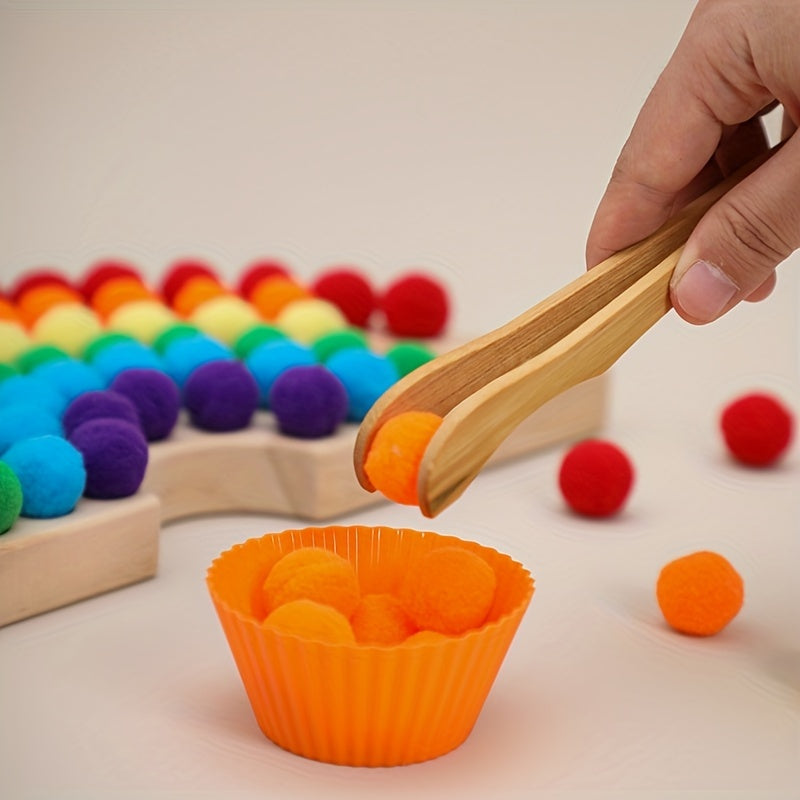 Child using wooden tong to place colorful pompoms into rainbow-themed silicone cupcake molds.
