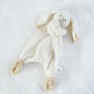 White plush bunny toy on a textured white surface