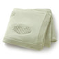 Light green knitted blanket with a heart design on a white background