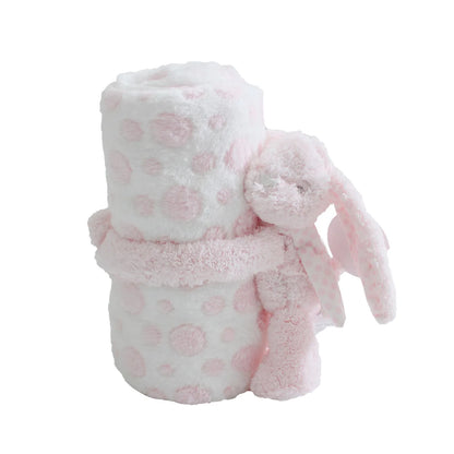 Fluffy pink and white polka dot blanket with a bunny toy on a white background