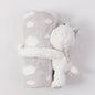 Plush toy with a unicorn horn and gray blanket on a light gray background