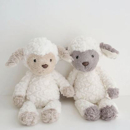 Two fluffy toy sheep on a light background