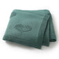 Green knitted blanket with heart patterns on a white background