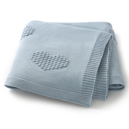 Folded light blue blanket with a heart design on a white background