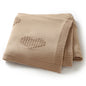 Folded beige blanket with a heart pattern on a white background